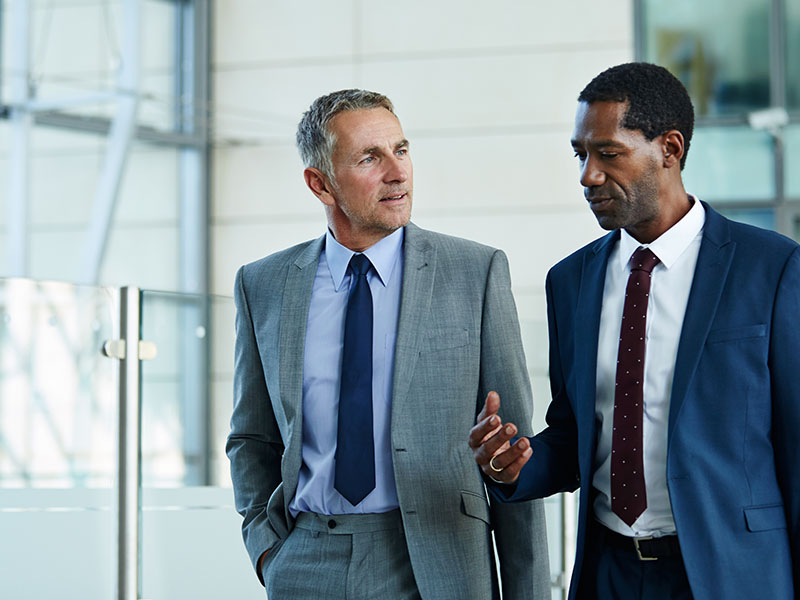 Smiling male realtor or broker shaking hand of excited buyers couple, negotiating about first house purchase or taking loan, insurance agent welcoming clients with handshake at consultation meeting Two Businessmen Talking