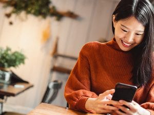 Young Asian beautiful woman using smart phone for business, online shopping, transfer money, financial, internet banking. in coffee shop cafe