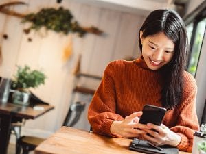 Young Asian beautiful woman using smart phone for business, online shopping, transfer money, financial, internet banking. in coffee shop cafe