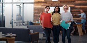 Three business women standing together in an office